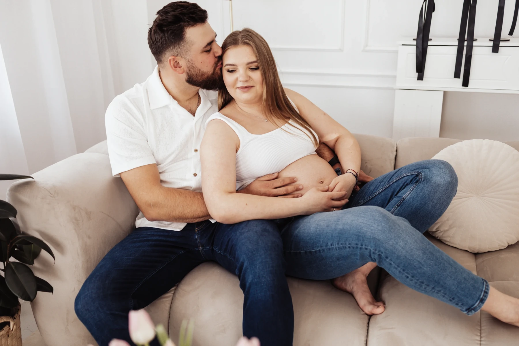 Sesja ciążowa — delikatny portret ciążowy w stonowanej, studyjnej scenerii